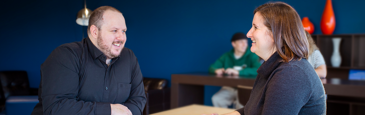 Deux personnes qui sourient, au café du Campus Premier Tech.