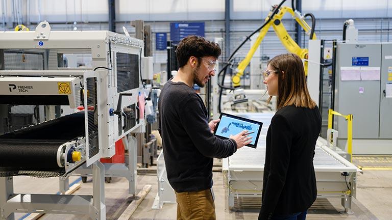 Équipiers parlant près d'une ligne de production