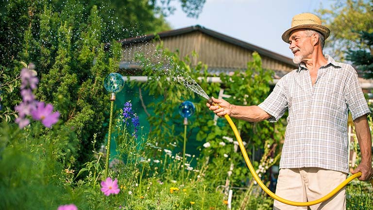 Un homme qui arrose son jardin