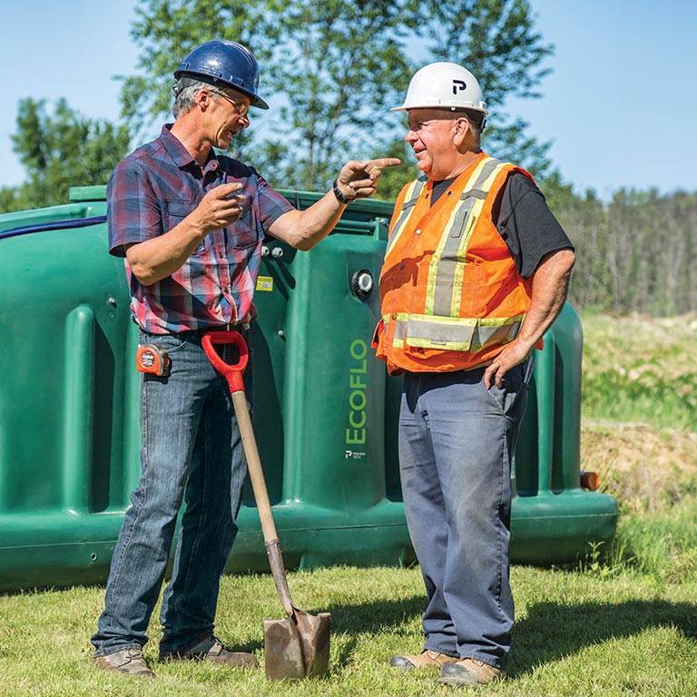 Two installers in front of an Ecoflo biofilter