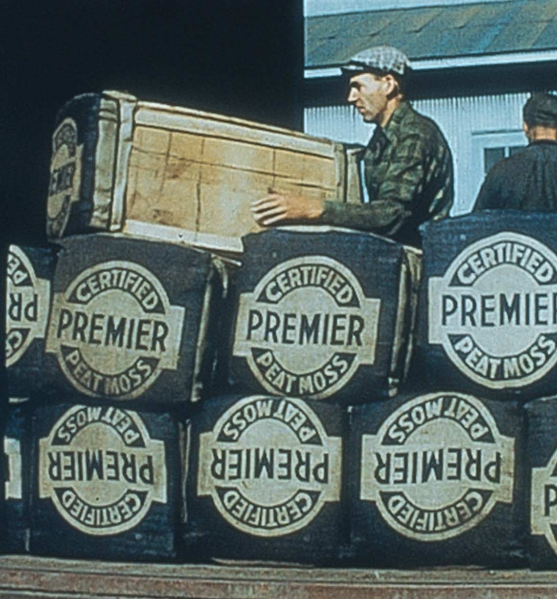 Workers carrying Premier Peat Moss in 1923
